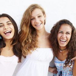 Portrait Of Three Teenage Girls Leaning Against Wall